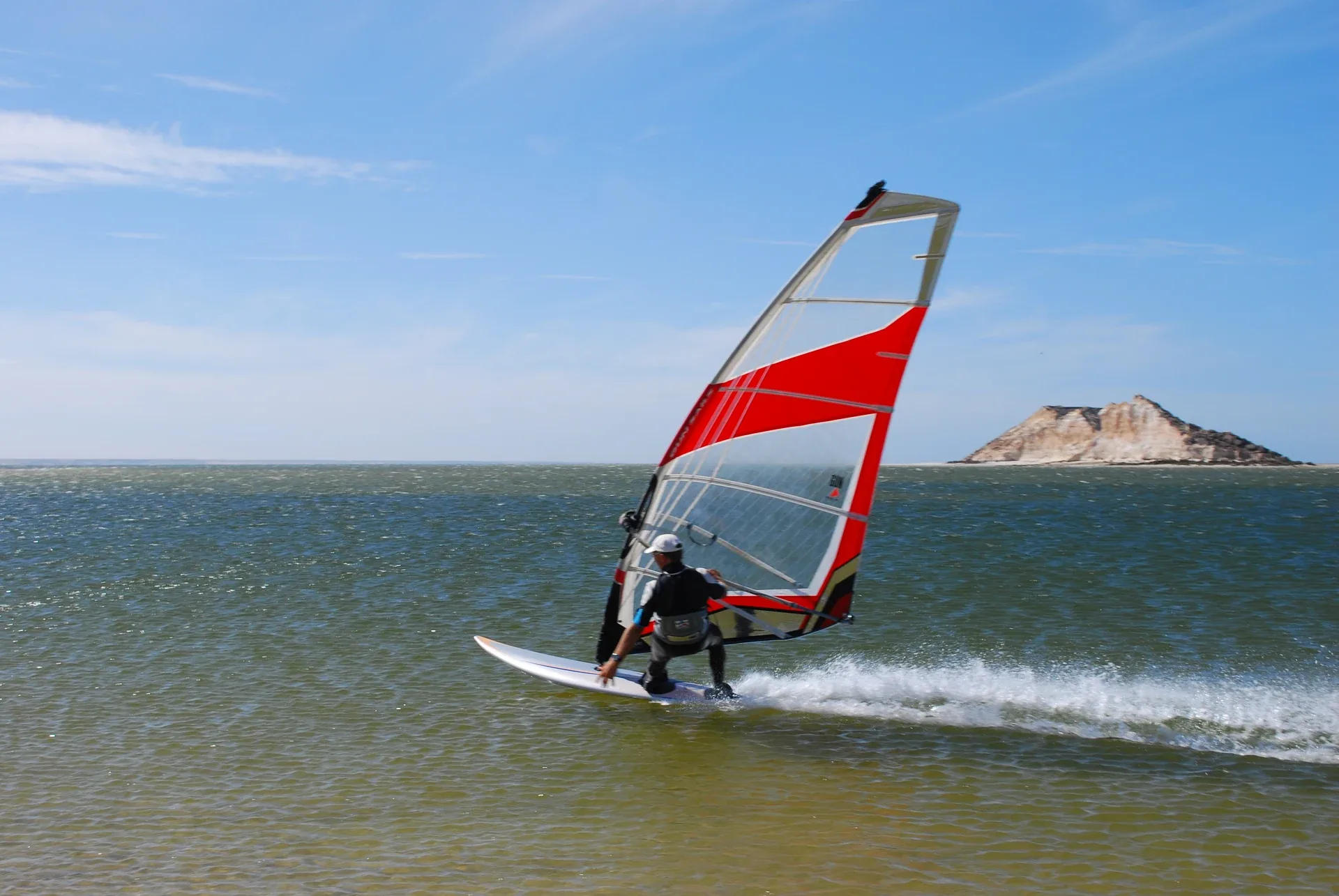 Windsurfista navegando frente a la isla del Dragón en Dakhla